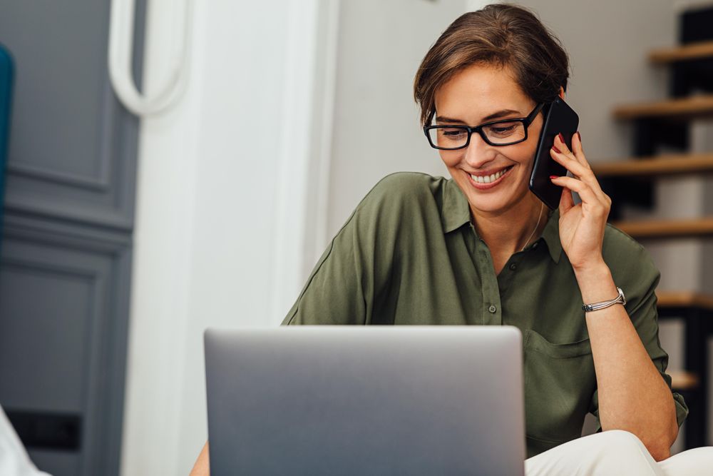 Female looking at laptop screen and smiling in hotel room