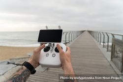 Man on boardwalk with remote for drone camera 0VRRj0