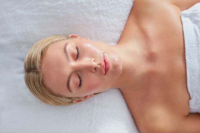 Blonde woman lying back before facial treatment