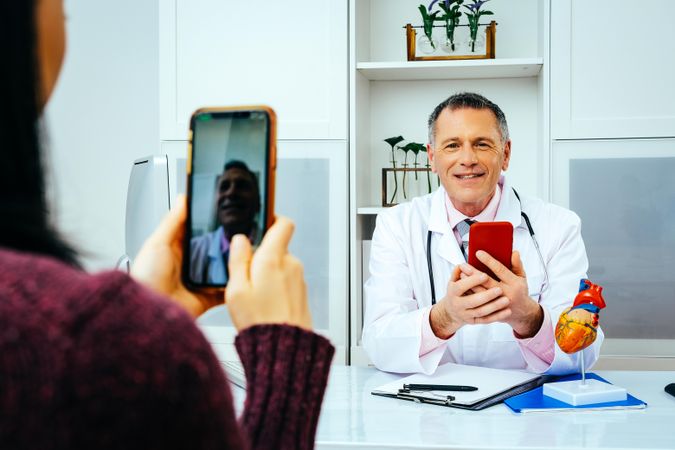 Physician taking video call with patient from his office