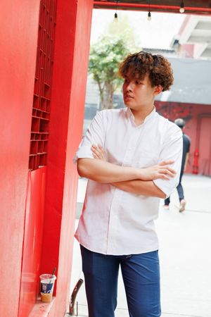 Portrait of Asian man in shirt and jeans standing in arms crossed