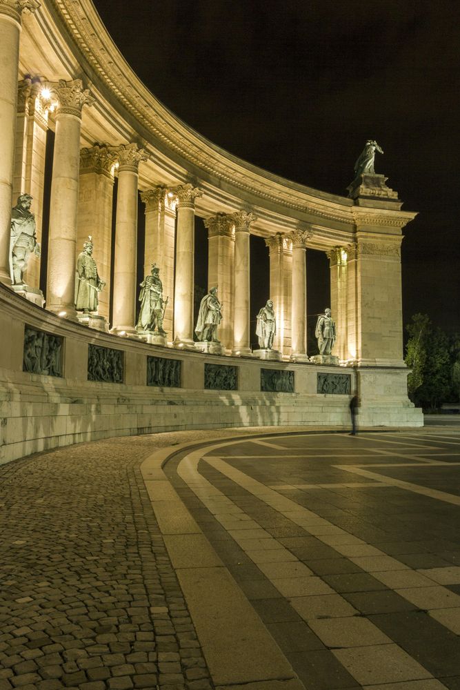 Columns from Heroes Square lit up at night, vertical