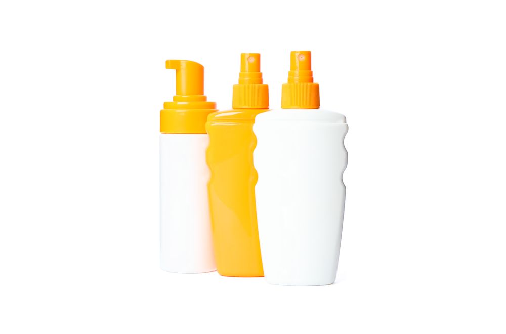 Sunscreen sprays isolated on studio background. Summer vacation accessories