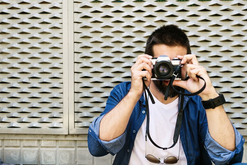 Man in denim taking photo outside