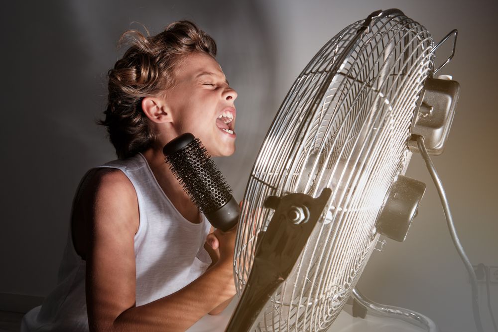 Cheerful boy screaming at fan
