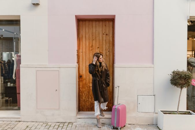 Stylish woman standing near brown door