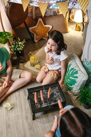 Top view of girl eating sausage with her family