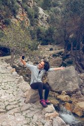 Joyful woman screaming and smiling while taking selfie i