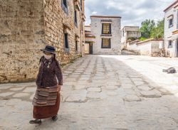 Tibet - August, 29 2014: woman in mask walking on street