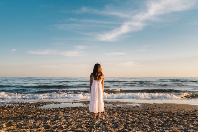 back view girl standing on beach in daylight