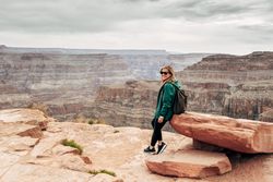 Female relaxing on cliff and admiring picturesque view