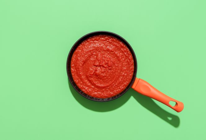 Italian tomato sauce top view on a green background