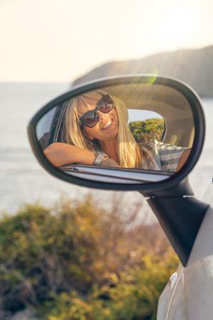 Vertical photo of a blonde woman with sunglasses looking at hers