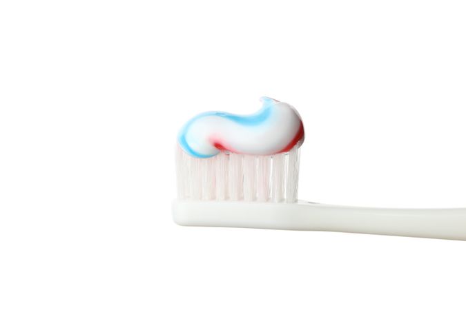 Toothbrush with toothpaste isolated on light background