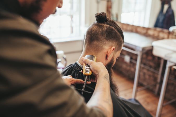 Barber trimming the back of customer’s hair