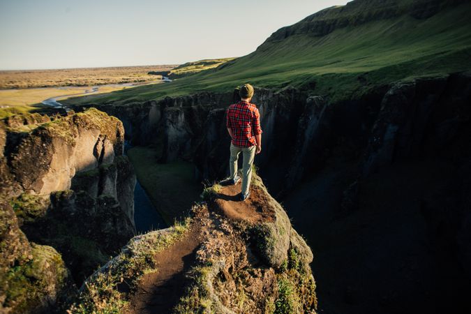 Back of man overlooking edge of cliff