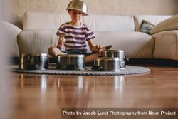 Little musician playing drums on kitchenware at home 48k8j5
