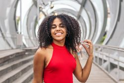 Portrait of a woman with afro hair enjoying in summer in the city