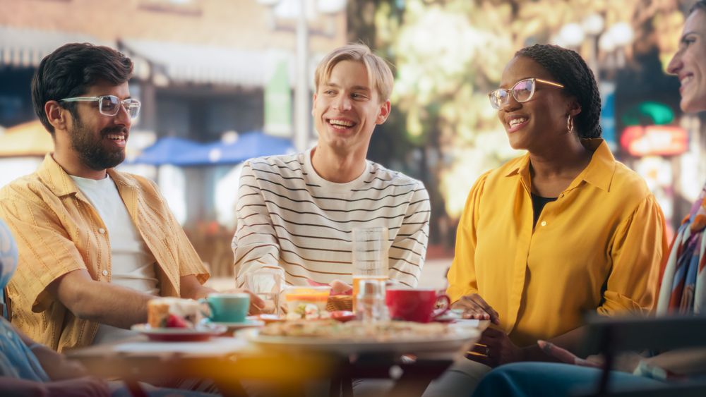 Young Multiethnic University Friends Enjoying the Weekend, Talking and Having Entertaining Time Outdoors
