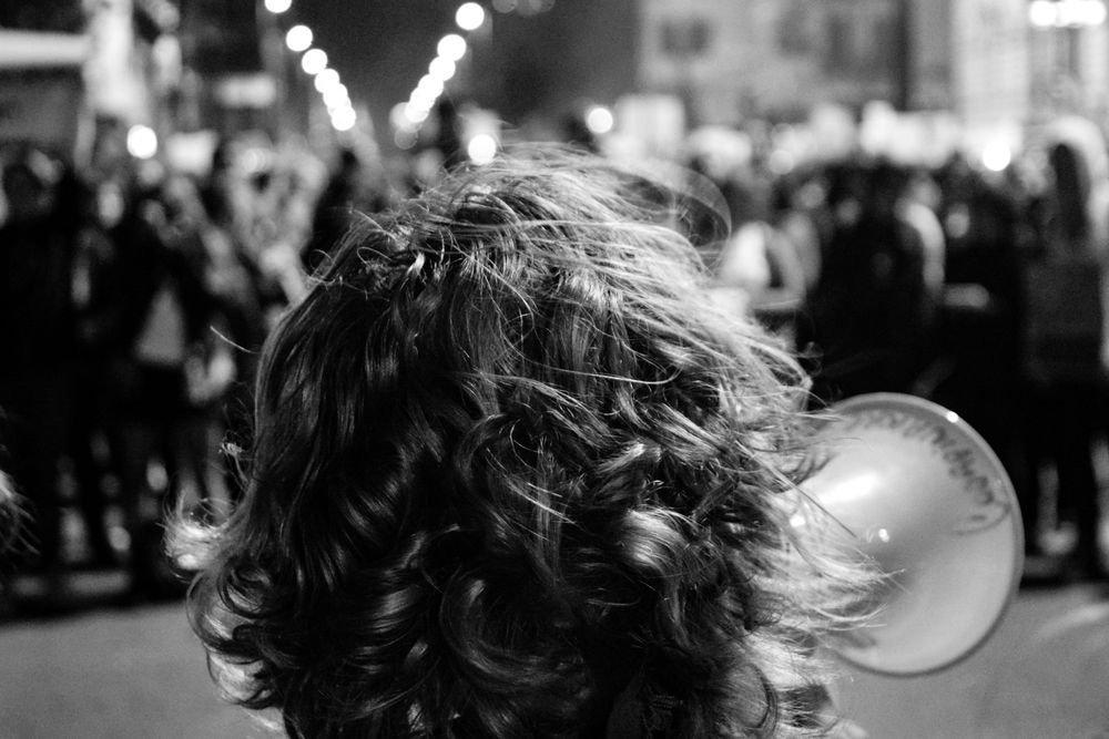 Back of head of someone using megaphone at protest