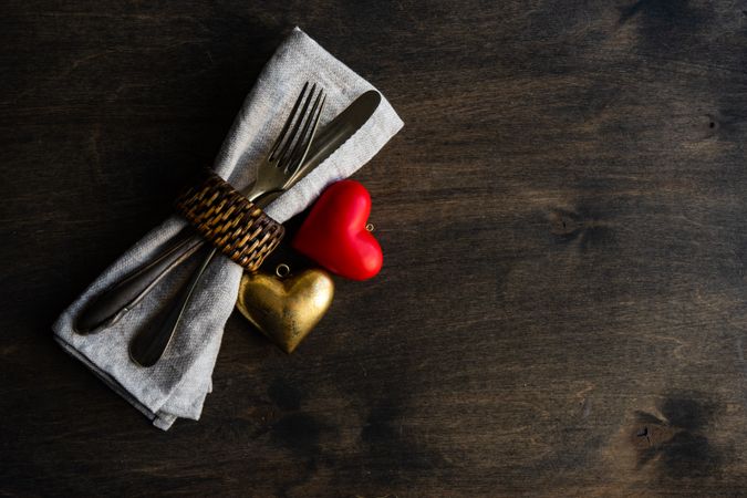 Napkin with napkin ring, silverware and heart decorations 
