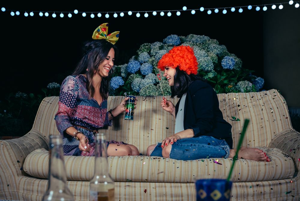 Happy women having fun sitting on sofa in party