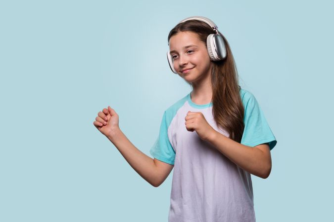 Girl dancing to music with headphones, enjoying the rhythm.