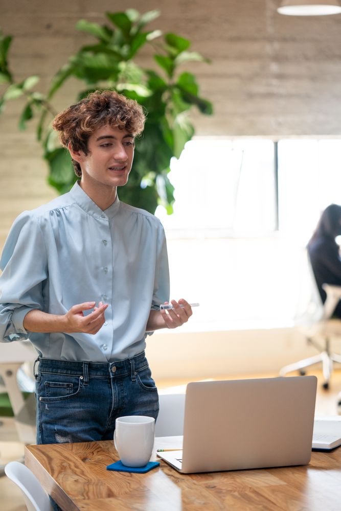 Person standing at wooden table in an open office