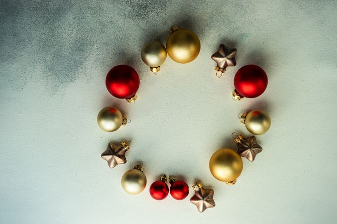 Circle of golden and red Christmas decorations on marble table