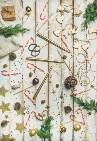 Decorations of stars, candy canes, scissors, candles on light background, vertical composition