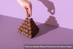 Chocolate truffles tower on a purple table in a bright light 4216y5
