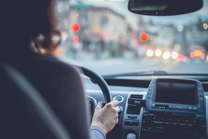 Woman driving car on city street