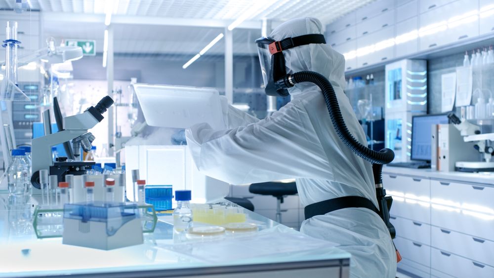 Medical Virology Research Scientist Works in a Hazmat Suit with Mask, She Takes out Test  Tubes from Refrigerator Box.