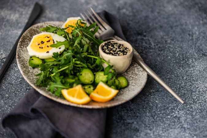 Healthy salad with hard boiled egg, cucumber with lemon slices and copy space