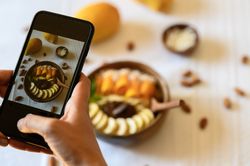 Crop person taking photo of healthy breakfast