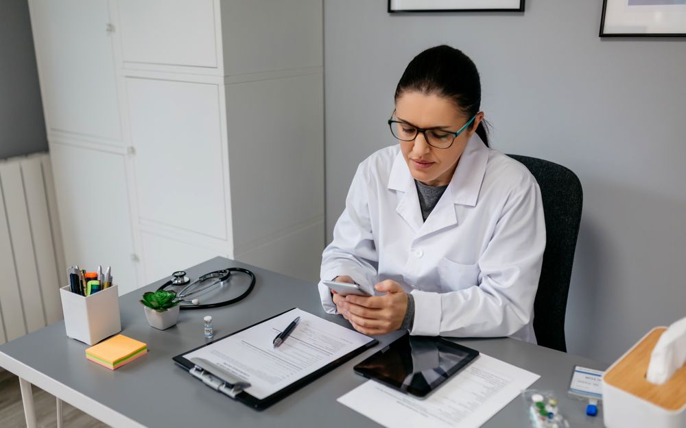 Female doctor using mobile while working