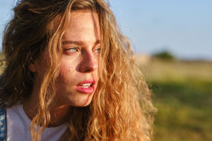 Crop young woman on grassy meadow