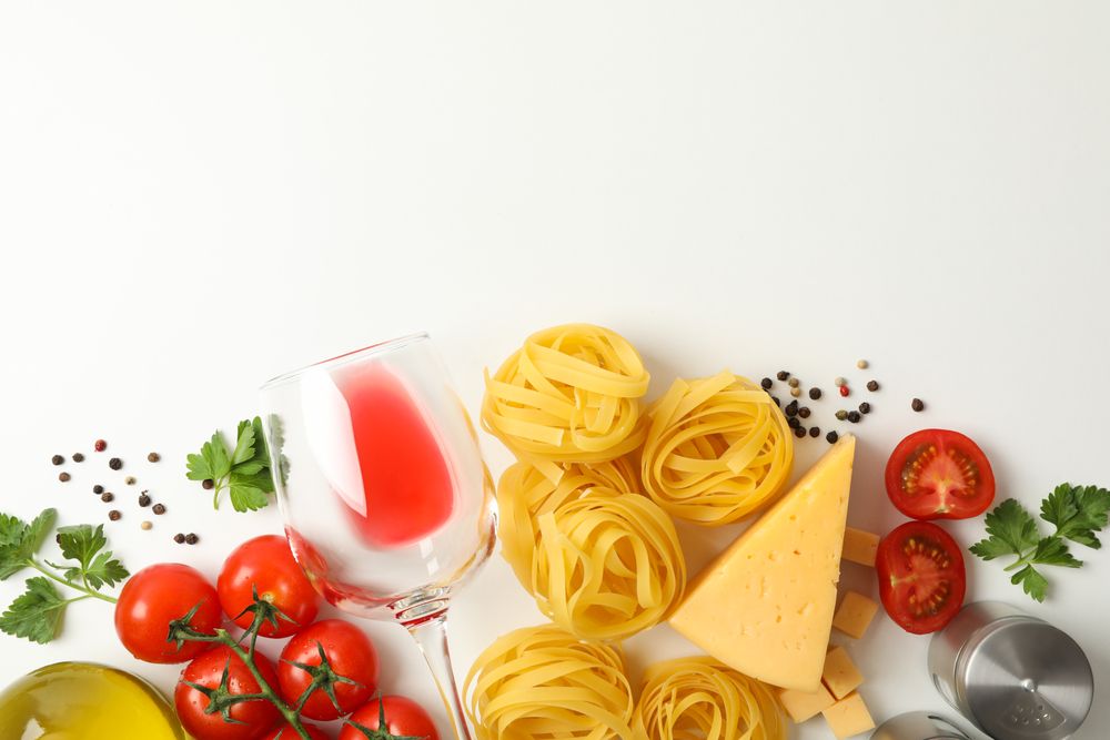 Composition with pasta and ingredients for cooking on plain background, top view