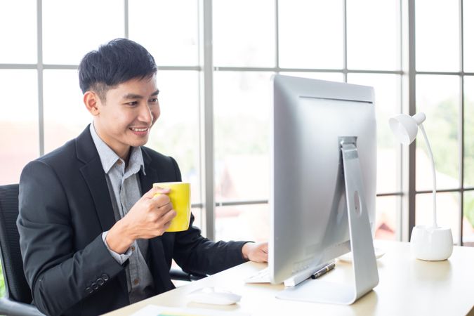 Businessman smiling looking at screen in the office