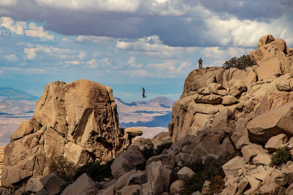 Person walking on rope between two rocky cliffs