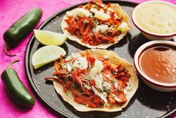 Pepper and lime near tacos al pastor and sauces
