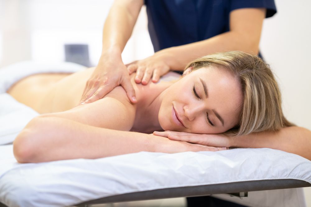 Blonde female having shoulders massaged