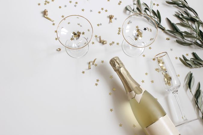 New year party, celebration with bottle of champagne wine, drinking glasses and olive branches