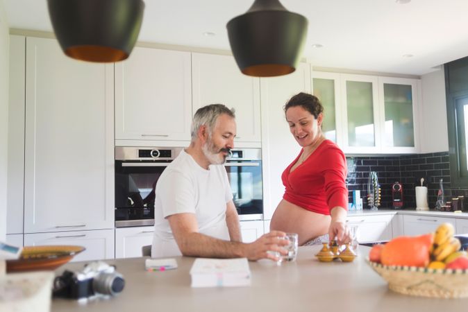 Expecting woman and husband in bright kitchen