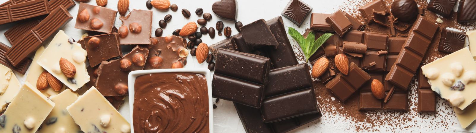 Chocolate, melted chocolate, coffee and almond on light background