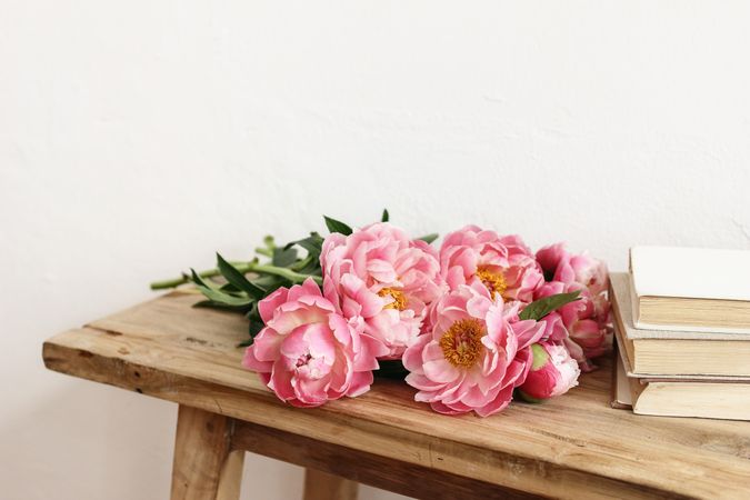 Pink peonies flower laying on wooden table