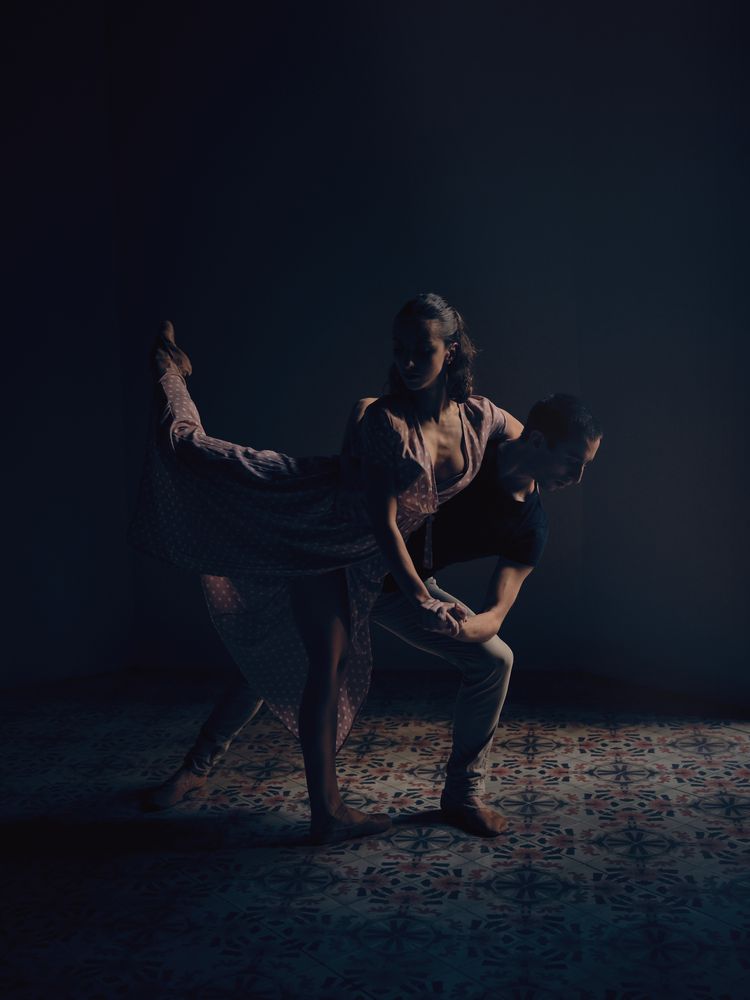 Couple dancing ballet in darkness