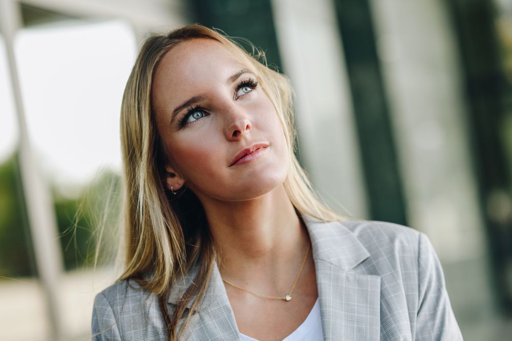 Portrait of woman in blazer looking up