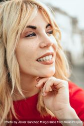 Blonde woman happy with head resting on her hand bG9Wa5