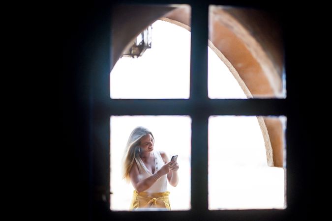 Woman using smartphone in balcony
